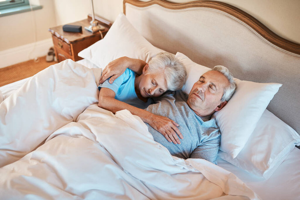 彼はまだ私が眠りに落ちるまで私を保持します。老人ホームでベッドで寝ている間に愛し合う先輩夫婦が抱き合う姿を切り撮り. - 写真・画像