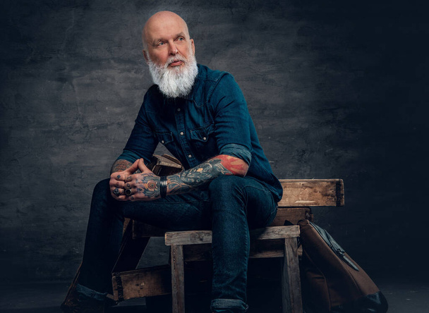 Stylish old hipster with tattooes against dark background - Fotoğraf, Görsel