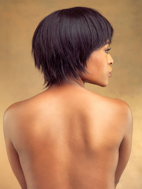 Ganzkörperperfektion. Rückseite Studioaufnahme einer schönen jungen Frau vor braunem Hintergrund. - Foto, Bild