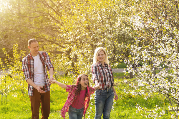 Boldog fiatal család töltenek időt együtt kívül zöld természet - Fotó, kép