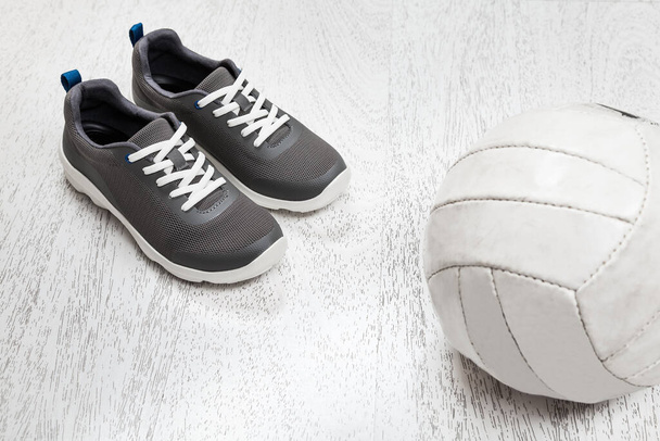 Active healthy living concept: running shoes, ball on white wooden background. - Foto, Imagen