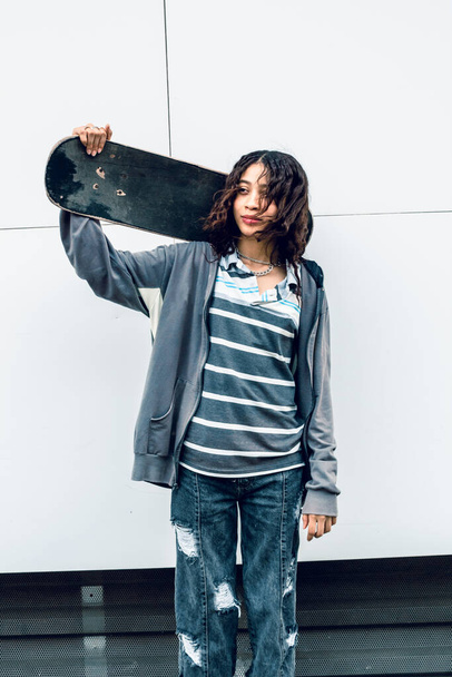 young woman with skateboard on the street isolated, on white - 写真・画像