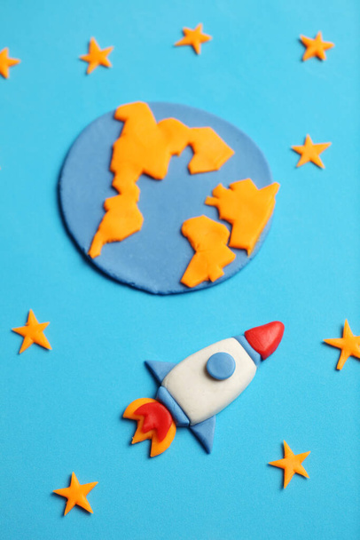 Kid (child) rocket in space, adventure and science. Stars, planet earth. Plasticine art, cartoon. - Photo, image