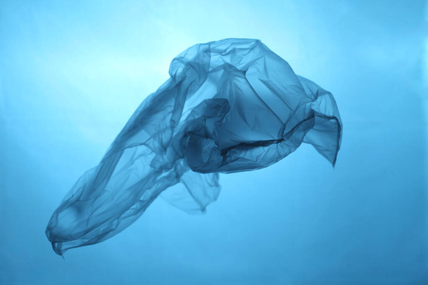 Plastic bag in blue water, garbage under water, plastic pollution of the oceans. - Foto, Bild