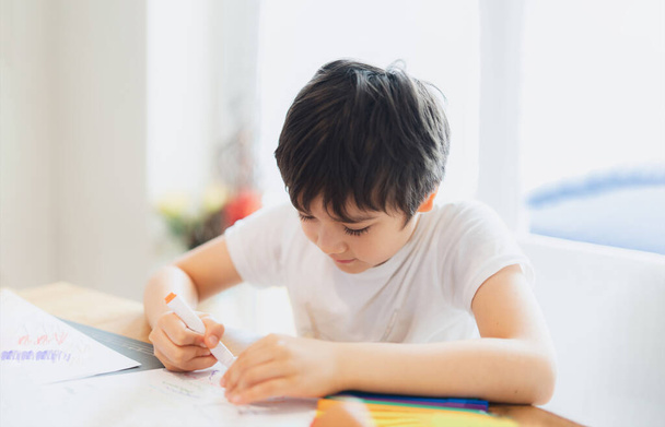 El niño de la escuela usando el dibujo de la pluma del color o escribiendo la letra en el papel, muchacho joven que hace la tarea, niño con las notas de la escritura de la pluma en hoja de papel durante la prueba del pupilo de lesson.Cute que hace, concepto de la educación en el hogar - Foto, Imagen