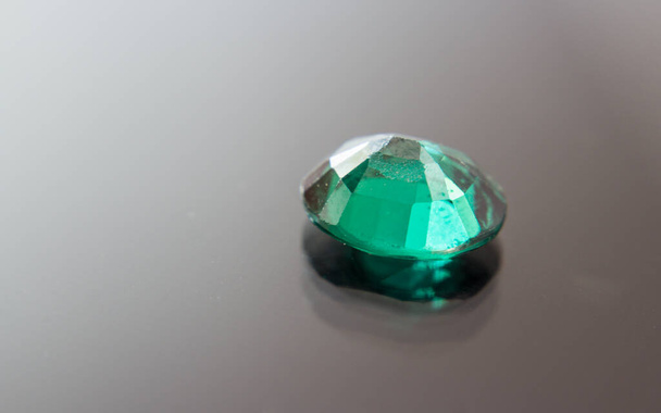Естественный зеленый сапфировый камень. Красивый зеленый драгоценный камень драгоценный камень изолирован на черном фоне, в качестве ювелирного фона - Фото, изображение
