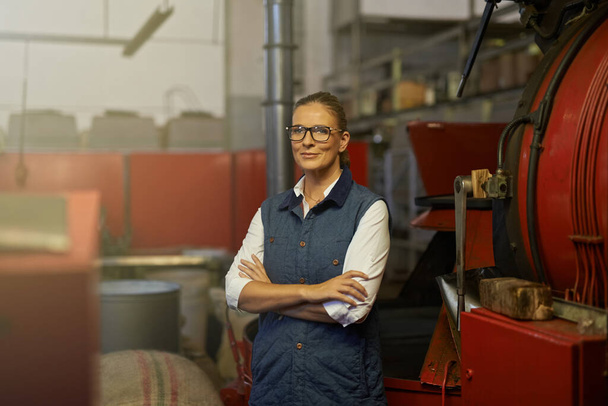 Start your day with my finest blend. Portrait of an industrious entrepreneur posing in front of machinery in her coffee roastery. - 写真・画像