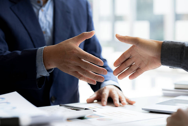Close-up two business men holding hands, Two businessmen are agreeing on business together and shaking hands after a successful negotiation. Handshaking is a Western greeting or congratulation. - Foto, Imagen