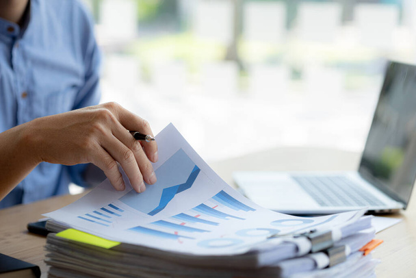 Business man pointing to a chart document showing company financial information, He sits in a private office, a document showing company financial information in chart form. Financial concepts - Foto, afbeelding