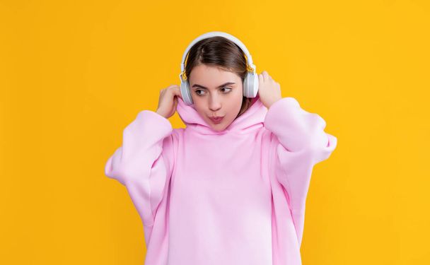 girl listen music in headphones on yellow background - Foto, afbeelding