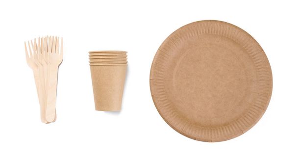 Brown paper cups, wooden fork and plates on a white background. Recyclable garbage, rejection of plastic, top view - Fotó, kép