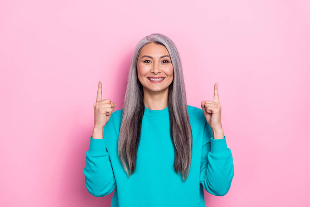 Portrait of cheerful pretty person direct fingers up empty space promotion banner isolated on pink color background - Foto, Imagem