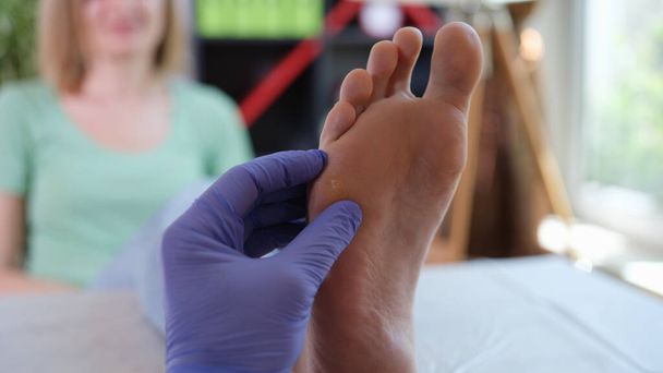 整形外科医は皮膚の問題で脚の検査を行います. - 写真・画像