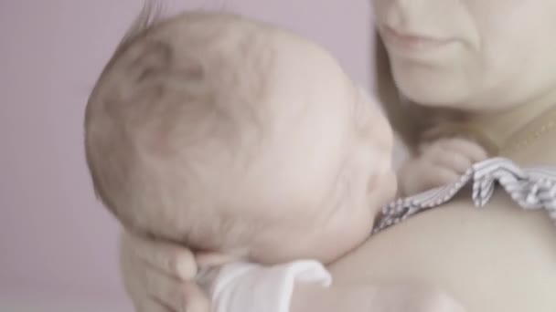 Lifestyle portret van een jonge moeder en haar pasgeboren, drie weken oude dochter. - Video