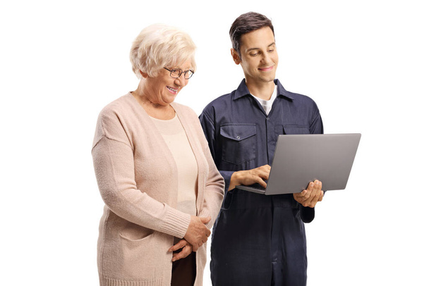 Male worker with a laptop computer showing to a casual elderly woman isolated on white background - Foto, imagen
