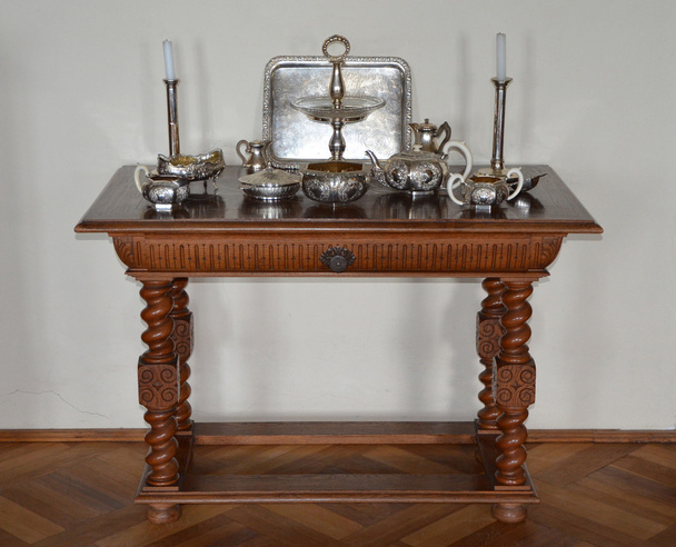 Антикварный стол для сервировки с серебряной посудой
 - Фото, изображение