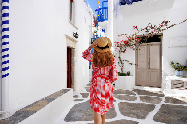 Tourist woman walks through the alleys in Mykonos picturesque town in Greece - Foto, imagen