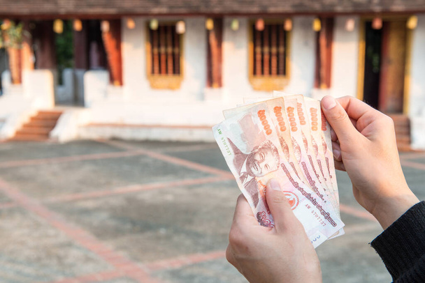 Gehakt beeld van iemand met bankbiljetten van Laos kipgeld (50.000 kip) de nationale munteenheid van Laos. - Foto, afbeelding