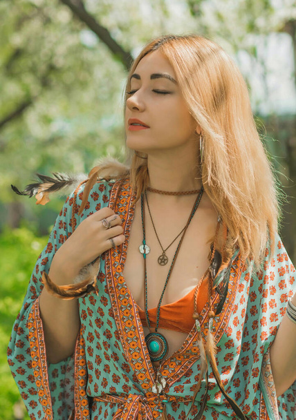 Ethnic hippie woman posing in boho style clothes at nature. Outdoor fashion. Concept of boho style and etno - Fotó, kép