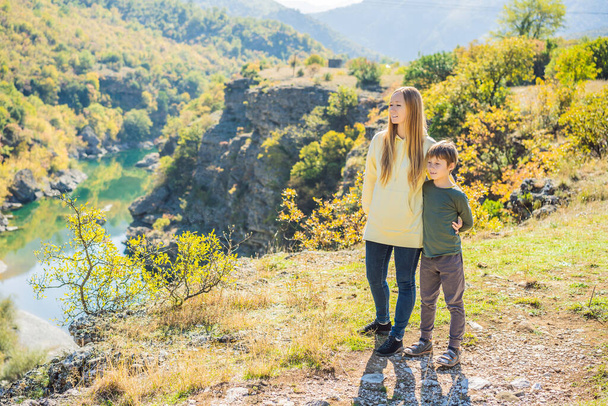 Montenegro. Mom and son tourists on the background of Clean clear turquoise water of river Moraca in green moraca canyon nature landscape. Travel around Montenegro concept - Photo, image