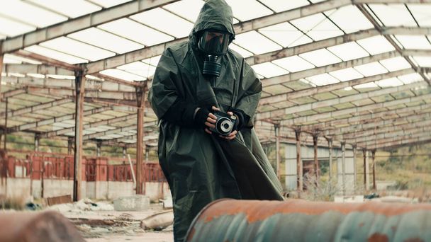 man with gas mask photographs the radioactive barrels - Фото, изображение