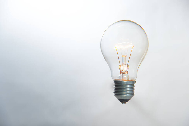 idea, tungsten light bulb lit on white background - Foto, Imagem