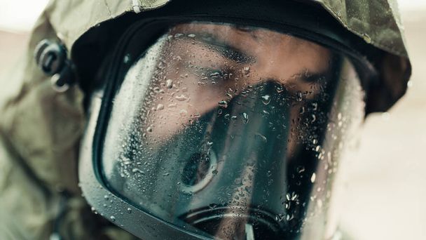 άνθρωπος με μάσκα αερίου κάτω από τη βροχή - Φωτογραφία, εικόνα