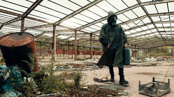 hombre con máscara de gas camina en un lugar abandonado - Foto, Imagen