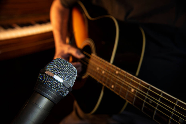 closeup silver metallic silver microphone on acoustic guitar background - Fotó, kép