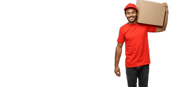 Concetto di consegna Ritratto di uomo di consegna afroamericano felice in panno rosso con in mano un pacchetto di scatole. Isolato su sfondo bianco studio. Copia spazio
 - Foto, immagini