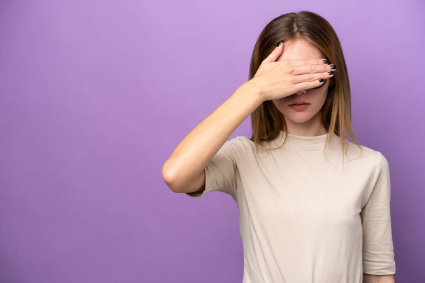 Молода англійська жінка ізольована на пурпуровому фоні, закриваючи очі руками. Не хочу нічого бачити. - Фото, зображення