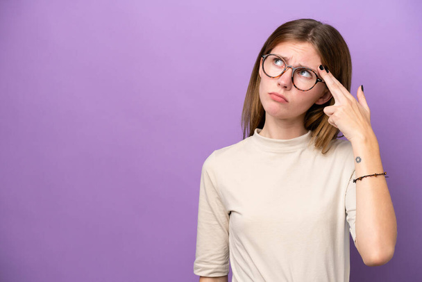 Young English woman isolated on purple background with problems making suicide gesture - Photo, Image