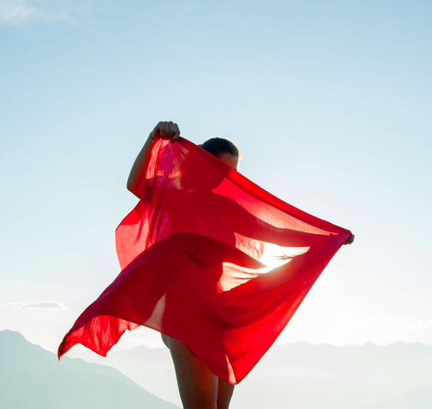 風に吹かれながら赤いスカーフに包まれた女 - 写真・画像