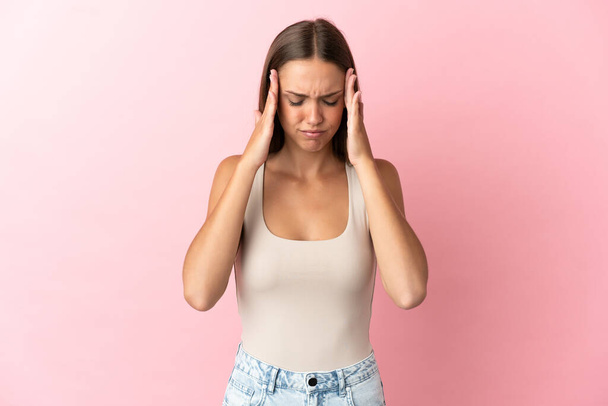 Junge Frau vor isoliertem rosa Hintergrund mit Kopfschmerzen - Foto, Bild