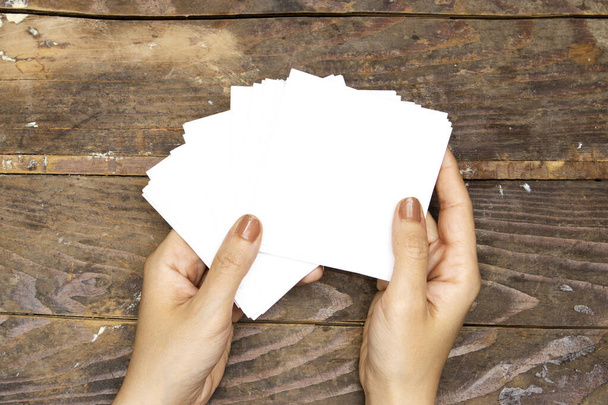 Руки крупным планом женщины держат чистые бумаги, рекламный щит для вашего дизайна или логотипа или текста - Фото, изображение