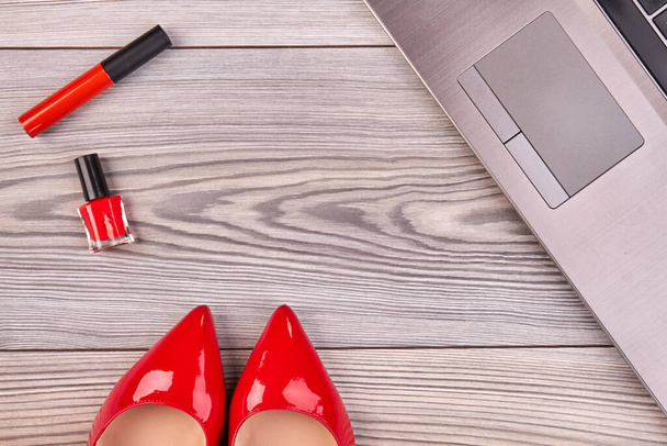 Red shoes with mascara and lacquer with laptop. - Photo, image