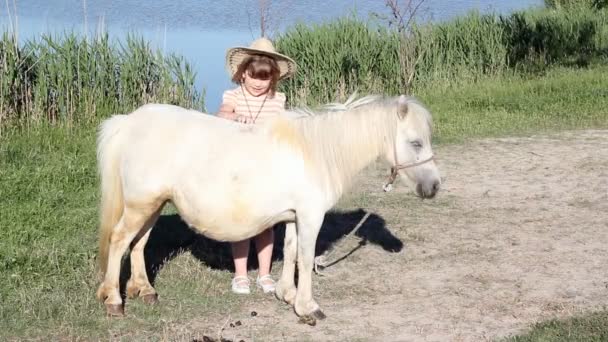 белый пони лошадь и маленькая девочка
 - Кадры, видео