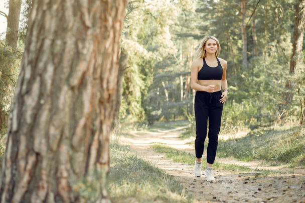 Beautiful woman runs in a summer park - Valokuva, kuva
