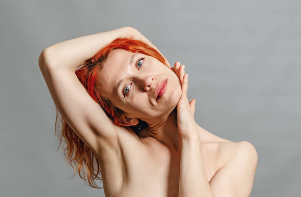 Attractive young woman with red hair is engaged in yoga, health concept, fitness concept. Woman stretches her neck - Fotó, kép