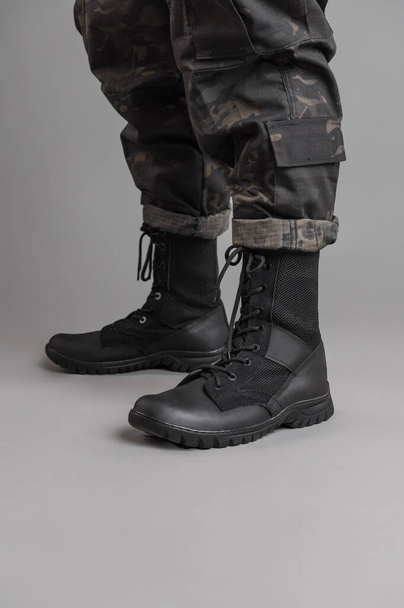 Leather military tactical boots on a Ukrainian soldier on a gray background - Foto, immagini