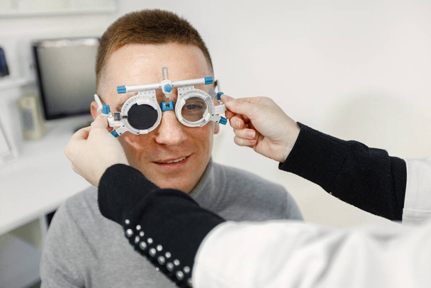 Man doing eye test checking examination at ophthalmology center - Fotoğraf, Görsel