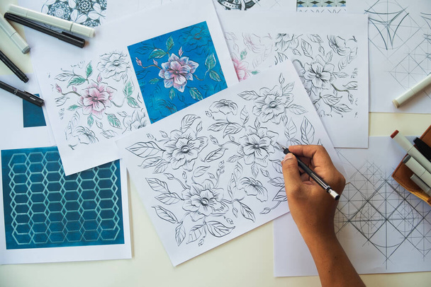 Designer designing drawing sketch pattern geometric flower seamless wallpaper fabric textile fashion industry. artistic design studio - Foto, immagini