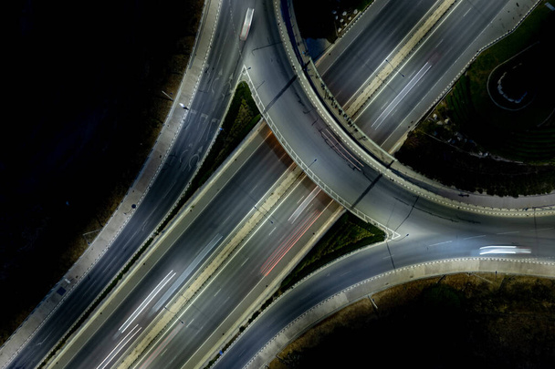 Aerial drone view of highway junction. Roundabout cars moving fast. Transportation infrastructure - Фото, изображение