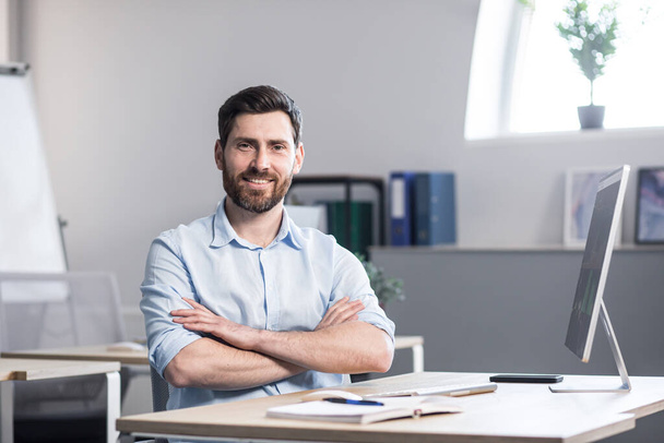 Portrait young handsome Confident bearded man, university lecturer, teacher, office worker. cheerful male Employee, entrepreneur or accountant independent looking at the camera crosses arms, smiling - Фото, изображение