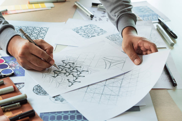 Designer designing drawing sketch pattern geometric flower seamless wallpaper fabric textile fashion industry. artistic design studio - Foto, imagen