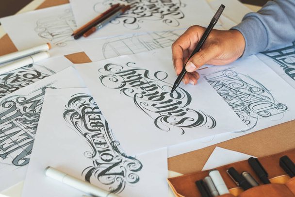 Typography Calligraphy artist designer drawing sketch writes letting spelled pen brush ink paper table artwork.Workplace design studio. - Foto, immagini
