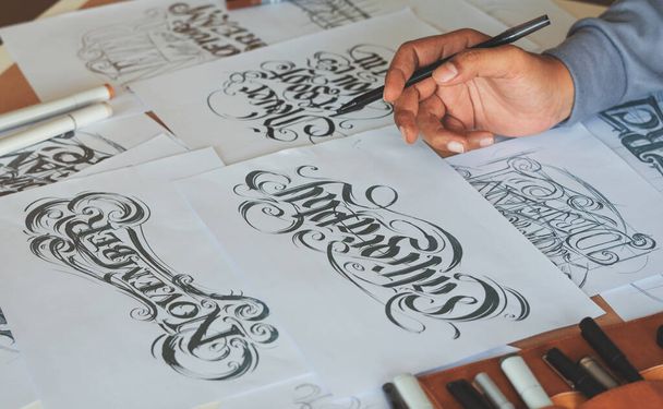 Typography Calligraphy artist designer drawing sketch writes letting spelled pen brush ink paper table artwork.Workplace design studio. - Photo, Image