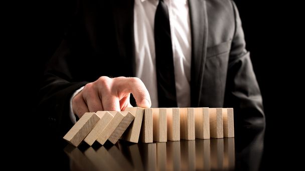 Businessman Stopping the Domino Effect - Zdjęcie, obraz