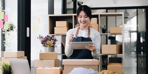 Small start-up business owners using computers at work, freelancers, saleswoman, checking production orders. Pack products for delivery to customers sell ecommerce delivery idea - Foto, imagen
