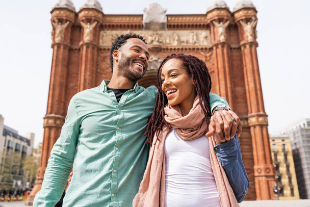 Beautiful happy hispanic latino couple of lovers dating outdoors - Tourists in Barcelona having fun during summer vacation and visiting Arc de Triumf historic landmark - Foto, Imagem